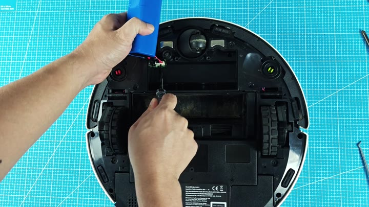 Disassembling robot vacuum on blue mat Disassembling robot vacuum on blue mat