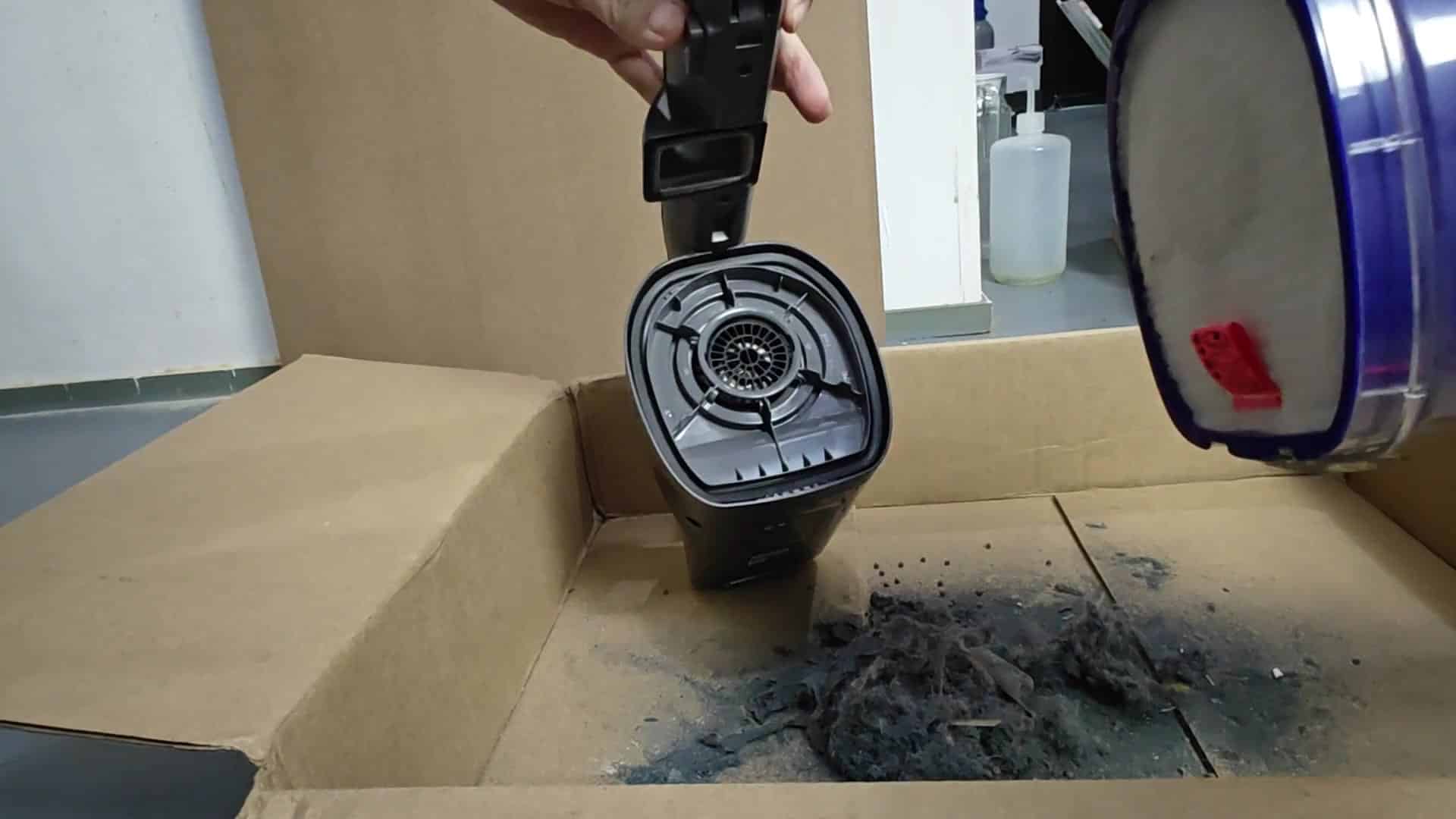 Dumping gray lint from vacuum bin Dumping gray lint from vacuum bin