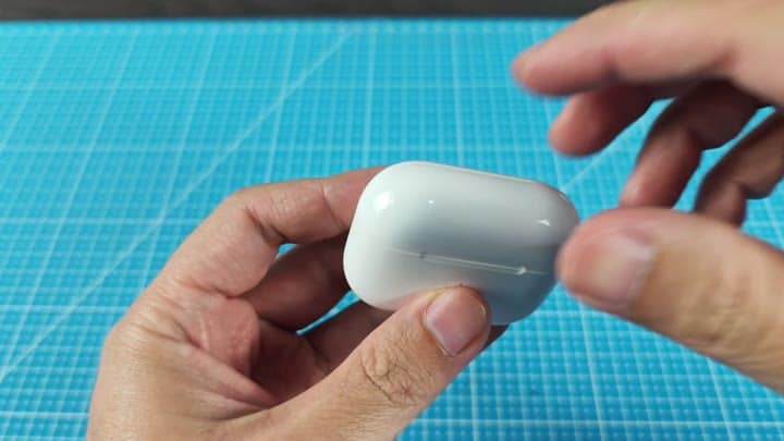 Opening the white charging case Opening the white charging case