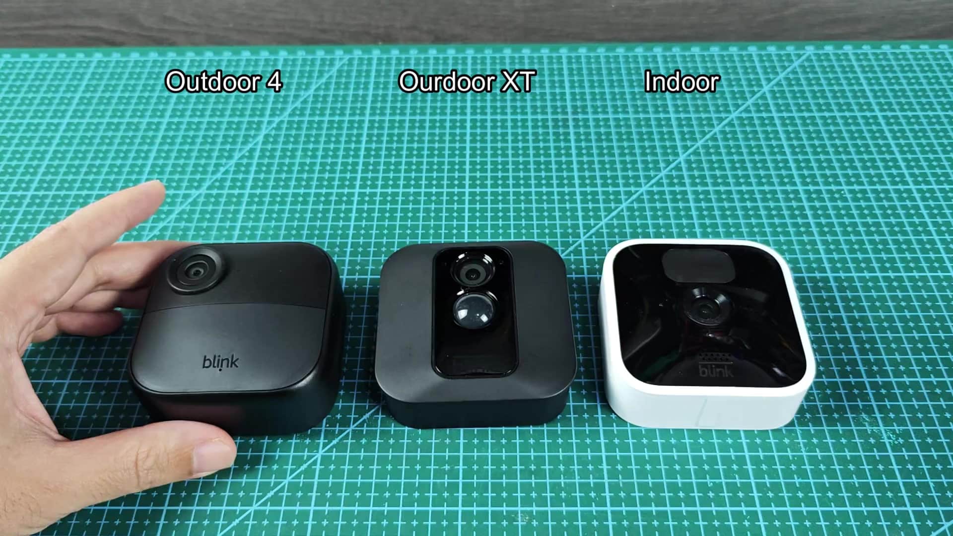 Three Blink cameras on green mat Three Blink cameras on green mat